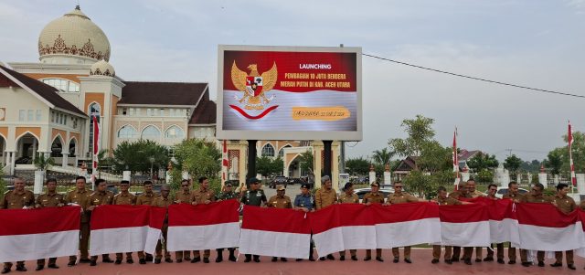 Pj Bupati Aceh Utara Bersama Pejabat Forkopimda dan Para ASN Setempat Berpose Dengan Bendera Merah Putih. (Foto: Ist/ Chairul Sya'ban/Lingkarkita.com)